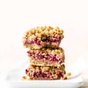 Three healthy raspberry oatmeal bars on top of each other.