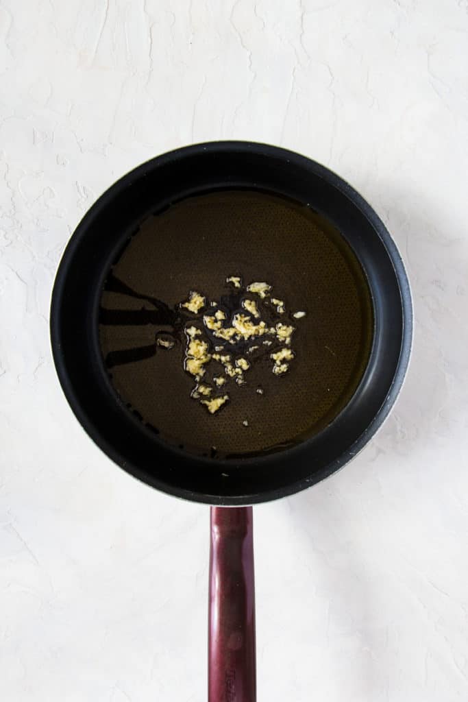 Minces garlic in a pan with olive oil