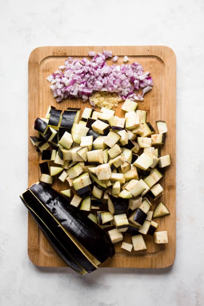 Epplants, onion and garlic on a cutting board