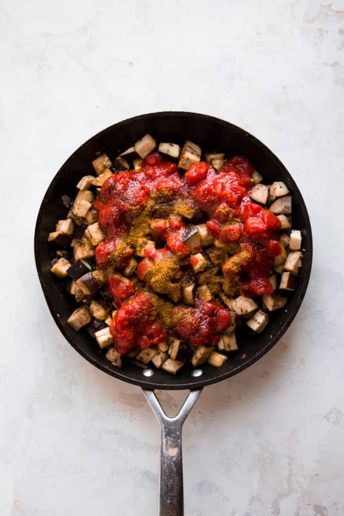 Eggplants with diced tomatoes in a pan
