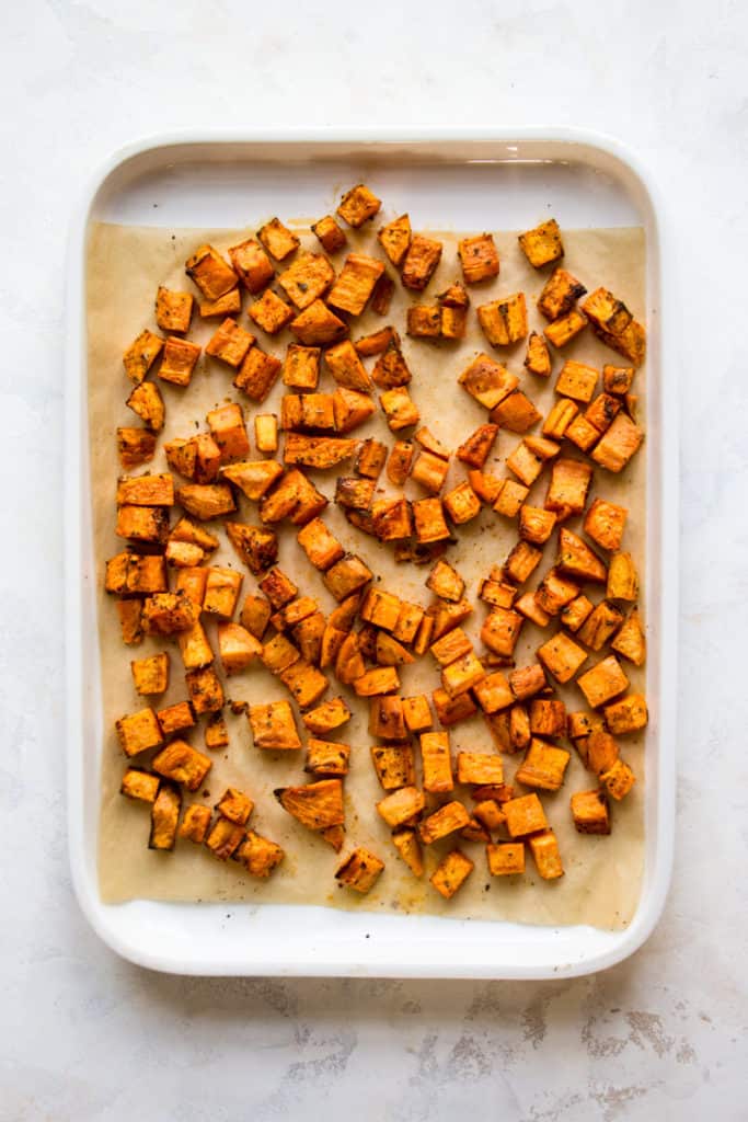 Oven-roasted sweet potato cubes on a baking sheet
