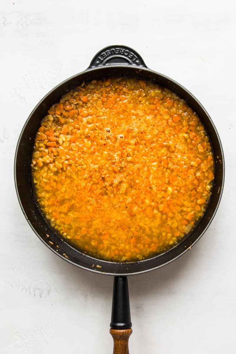 Rice and vegetable broth in a pan.