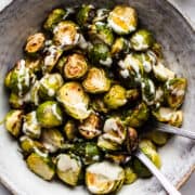 Vegan roasted Brussels sprouts with caesar dressing in a bowl.
