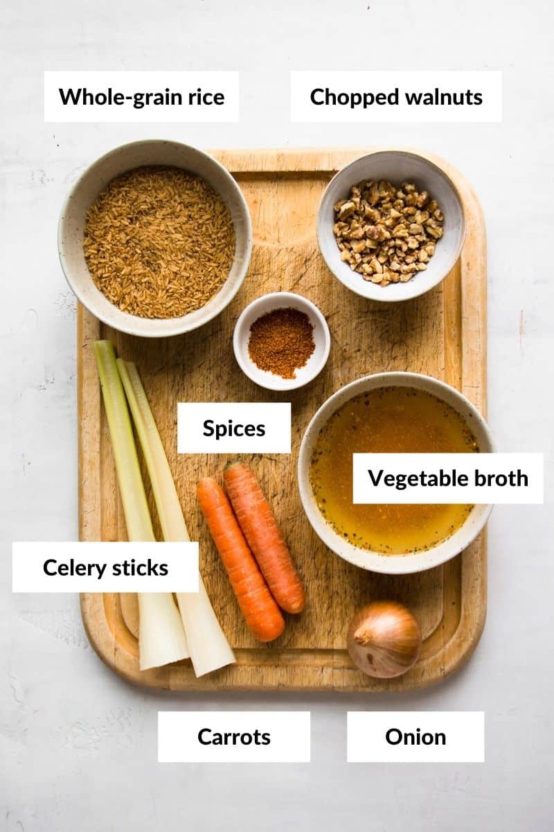 Vegetable broth, rice, walnuts and spices in small bowls.