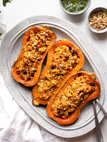 Butternut squash boats stuffed with rice on a serving platter.