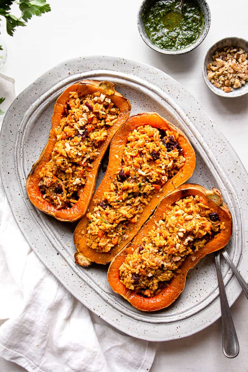 Butternut squash boats stuffed with rice on a serving platter.