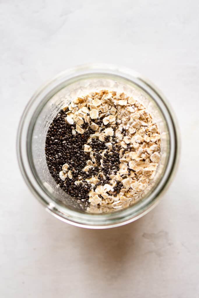 Rolled oats and chia seeds in a glass jar.