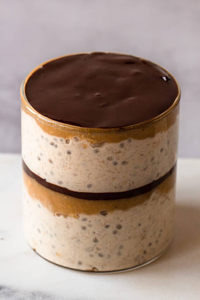 Oats, caramel and chocolate layered in a small jar.