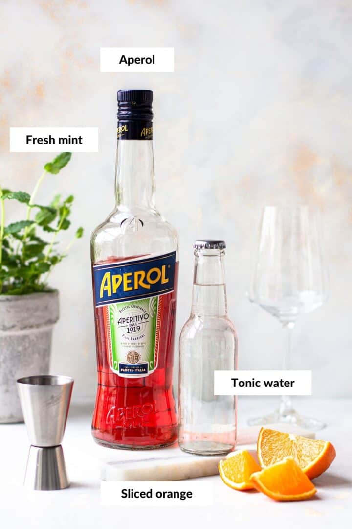 Bottle of Aperol and tonic water with descriptive labels.