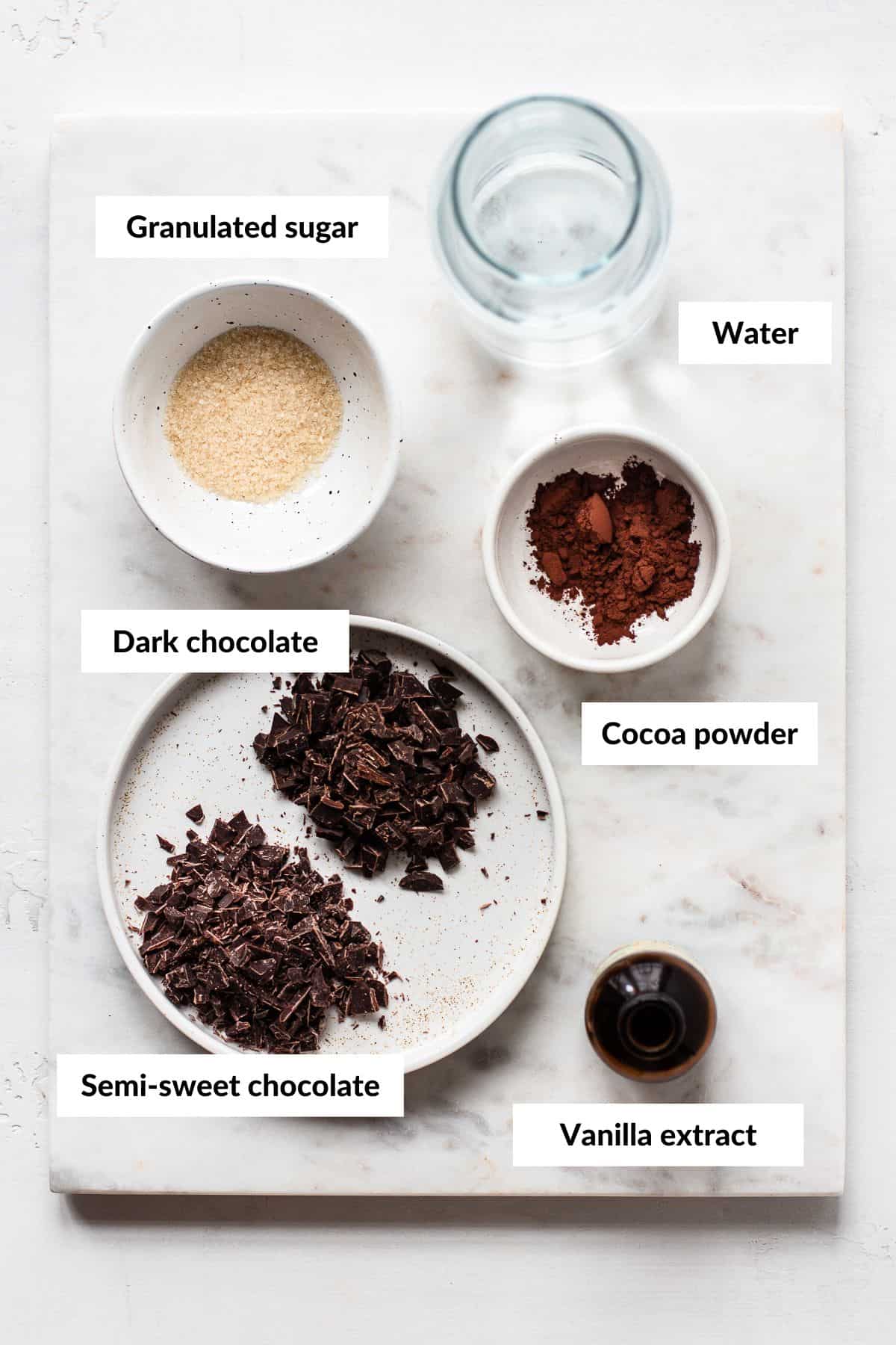 Ingredients for hot chocolate in small bowls with descriptive labels.