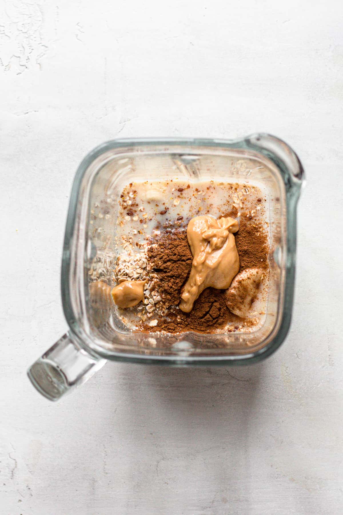 Milk, frozen banana slices, peanut butter, ground cinnamon and flax seeds in a blender.