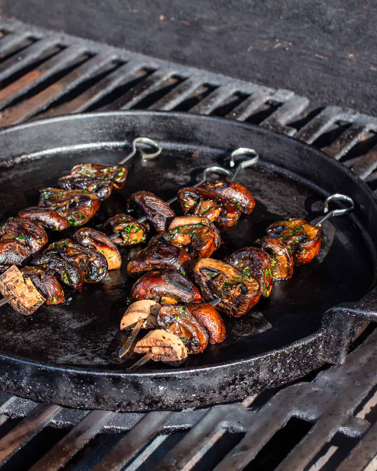 Grilled mushroom skewers on a griddle on a gas grill.