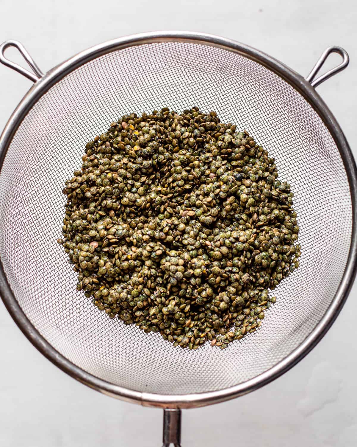 Rinsed puy lentils in a fine-mesh sieve.