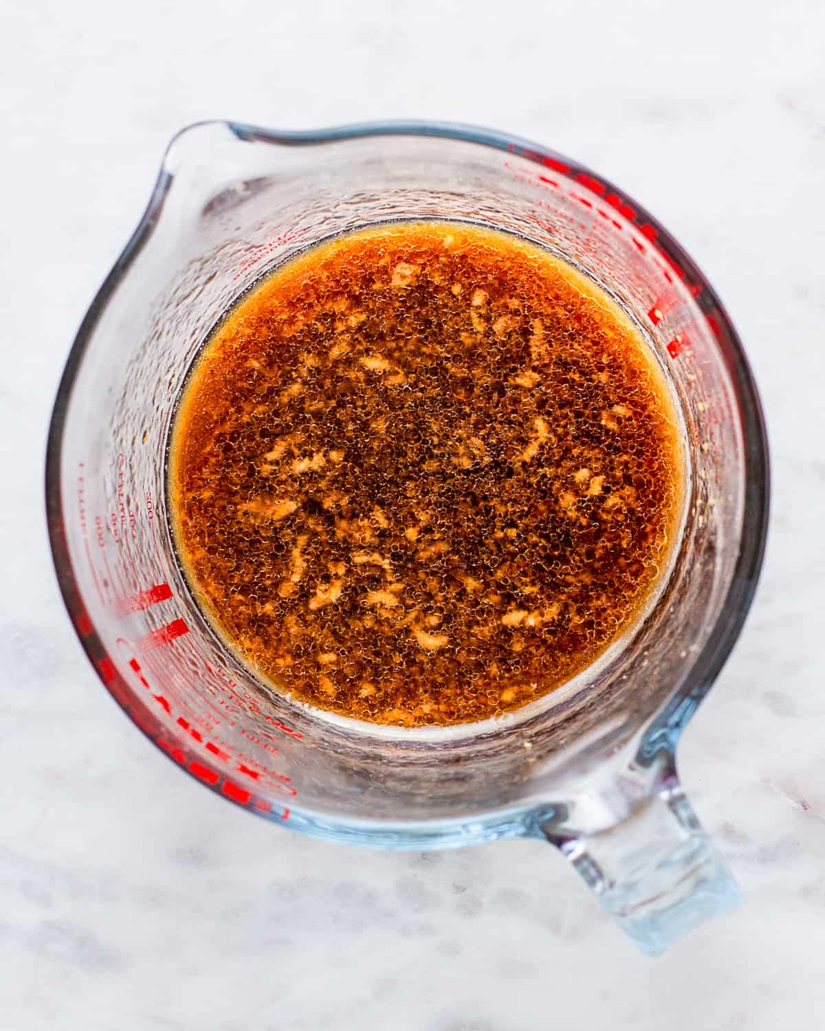 Asian-inspired dressing made with tamari, ginger, and garlic in a glass pitcher.