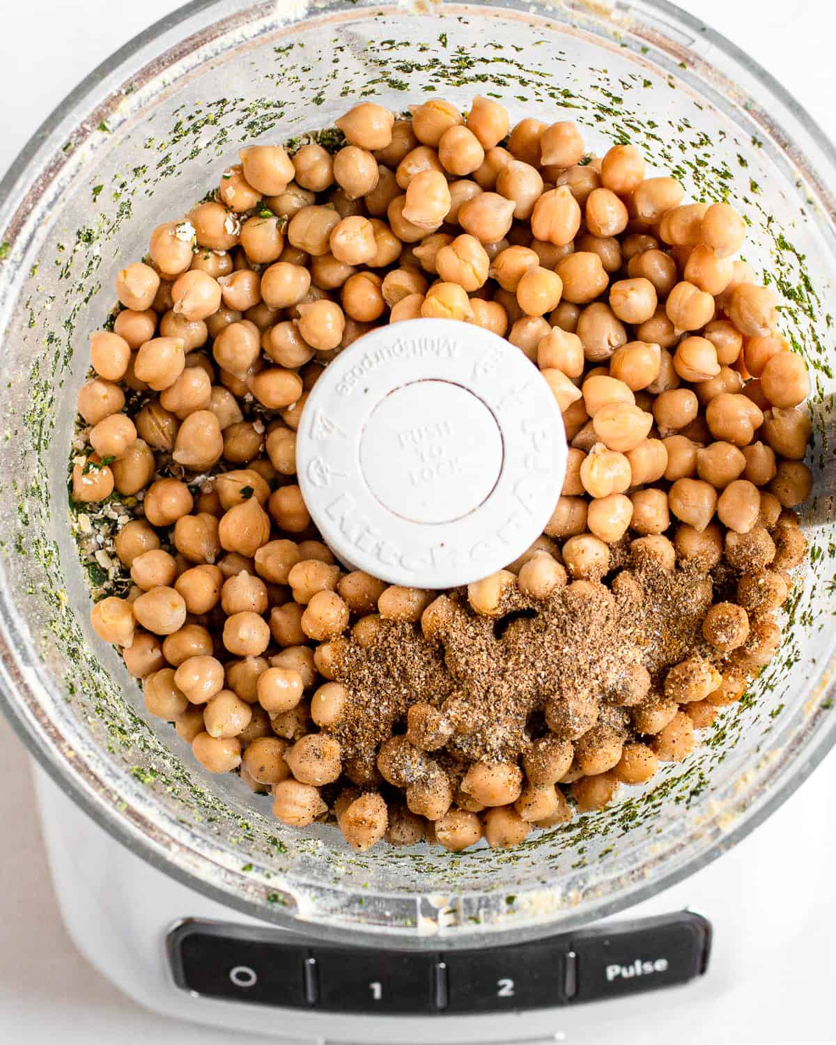 Herbs, drained canned chickpeas, and spices in a food processor.