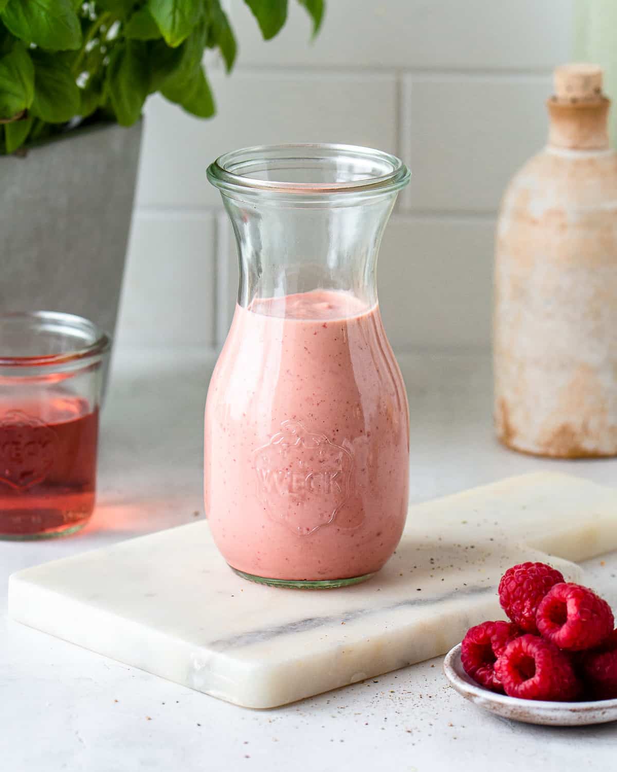 Pink raspberry salad dressing in a glass jar 
