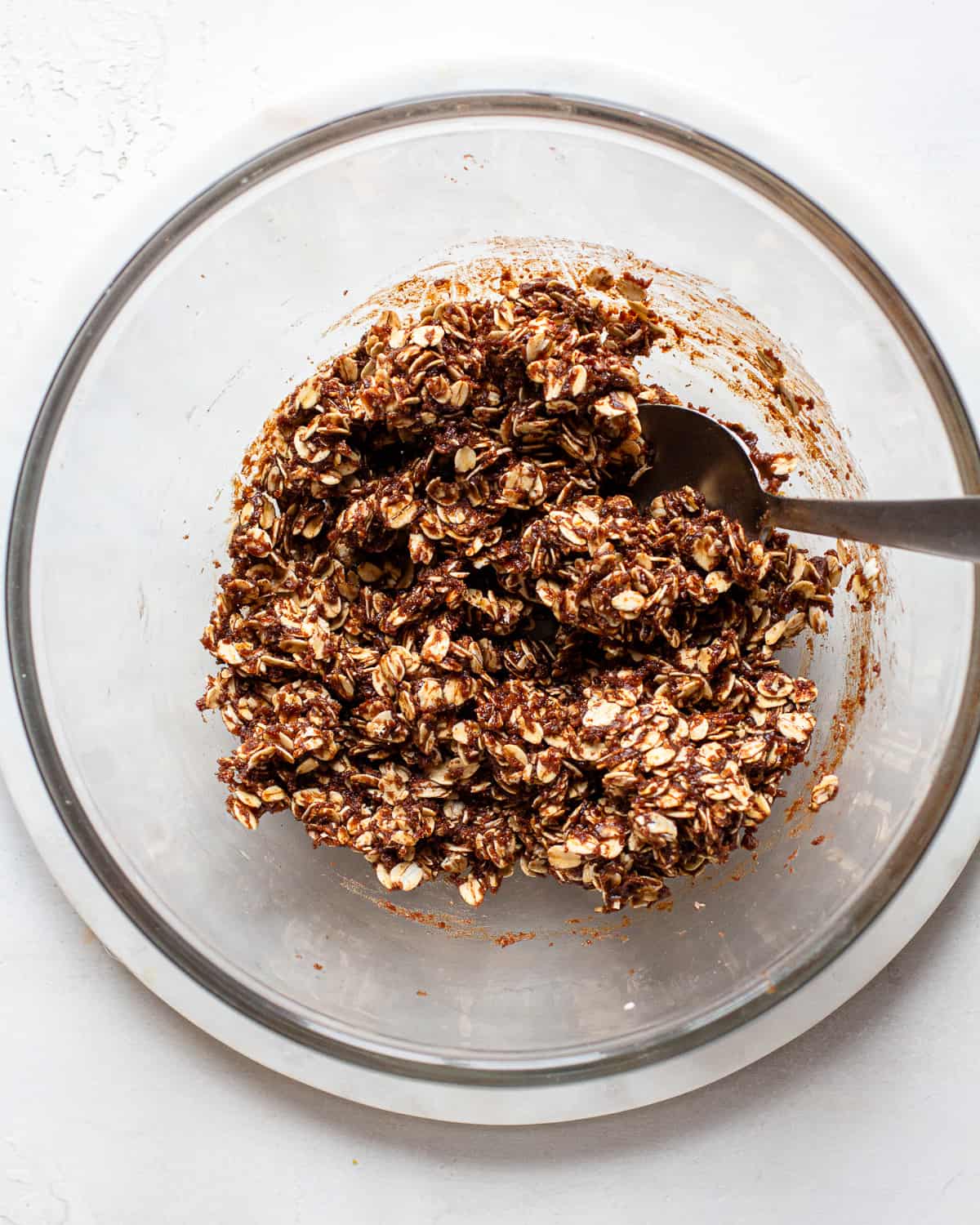 Carob energy ball mixture in a glass mixing bowl.