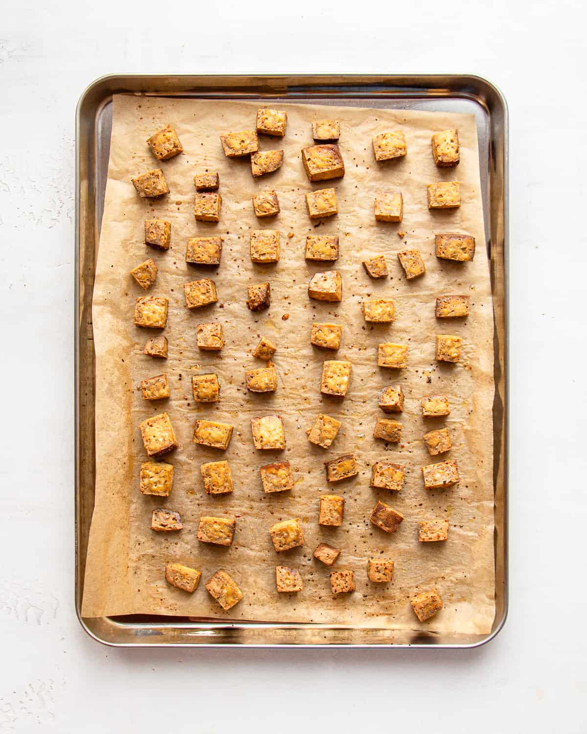 Crispy baked tofu on a baking sheet.