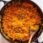 Finely chopped carrots, onion, and celery in a black Dutch-oven.