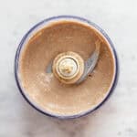 Light brown batter in a small food processor.